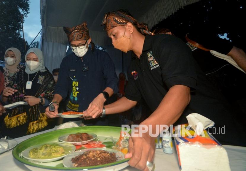 Menparekraf Sandiaga Uno (ketiga kiri) melihat kuliner yang ditawarkan peserta ADWI 2021 di Kampung Minang Nagari Sumpu, Kabupaten Tanah Datar, Sumatra Barat, Sabtu (28/8/2021). 