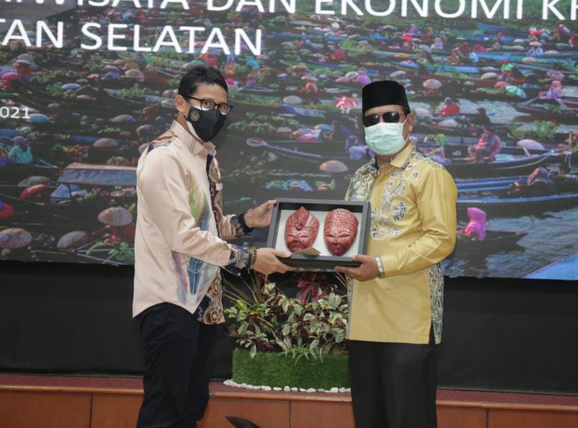 Menteri Pariwisata dan Ekonomi Kreatif (Menparekraf) Sandiaga Uno menyerahkan cendera mata kepada Gubernur Kalsel H Sahbirin Noor saat melakukan kunjungan kerja ke Kalimantan Selatan, Rabu (1/9/2021).