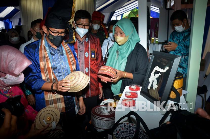 Menteri Pariwisata dan Ekonomi Kreatif Sandiaga Salahuddin Uno (kedua kiri) mengunjungi stan pameran UMKM di Anjungan Pantai Losari, Makassar, Sulawesi Selatan, Kamis (24/2/2022). Sandiaga mengapresiasi Pemda Sulsel dalam pencapaian jumlah UMKM sebanyak 1,2 juta pelaku yang telah melakukan transformasi dalam bentuk digital sebagai upaya memaksimalkan pemasaran produk di tingkat nasional maupun internasional. 