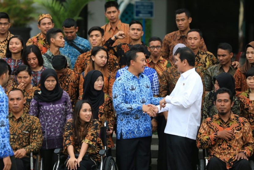 Menteri Pemberdayaan Aparatur Negara dan Reformasi Birokrasi (MenPAN RB) Asman Abnur (kanan) berjabat tangan dengan Menteri Pemuda dan Olahraga (Menpora) Imam Nahrawi saat mengumumkan pengangkatan 130 atlet berprestasi menjadi Calon Pegawai Negeri Sipil (CPNS) dengan formasi khusus di Halaman Kantor Kementerian Pemuda dan Olahraga, Jakarta, Rabu (17/1) pagi.