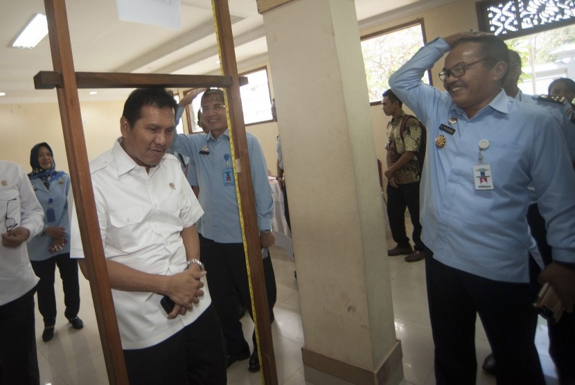 Menteri Pendayagunaan Aparatur Negara dan Reformasi Birokrasi (Menpan RB) Asman Abnur (kedua kiri) mencoba alat ukur tinggi badan saat meninjau tahapan seleksi calon pegawai negeri sipil Kementerian Hukum dan HAM di Denpasar, Senin (11/9). 