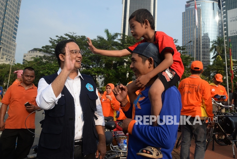 Menteri Pendidikan dan Kebudayaan Anies Baswedan berbincang dengan pengunjung car free day saat sosialisasi kampanye anter anak pada hari pertama sekolah di Patung Kuda, Jakarta, Ahad (17/7). (Republika/Yasin Habibi) 