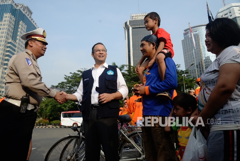 Menteri Pendidikan dan Kebudayaan Anies Baswedan berbincang dengan pengunjung car free day saat sosialisasi kampanye anter anak pada hari pertama sekolah di Patung Kuda, Jakarta, Ahad (17/7). (Republika/Yasin Habibi) 