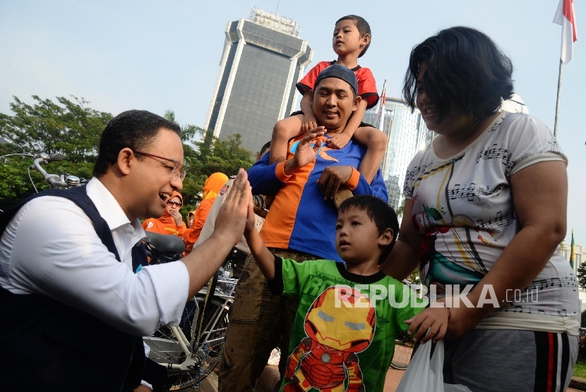 Menteri Pendidikan dan Kebudayaan Anies Baswedan berbincang dengan pengunjung car free day saat sosialisasi kampanye anter anak pada hari pertama sekolah di Patung Kuda, Jakarta, Ahad (17/7). (Republika/Yasin Habibi) 