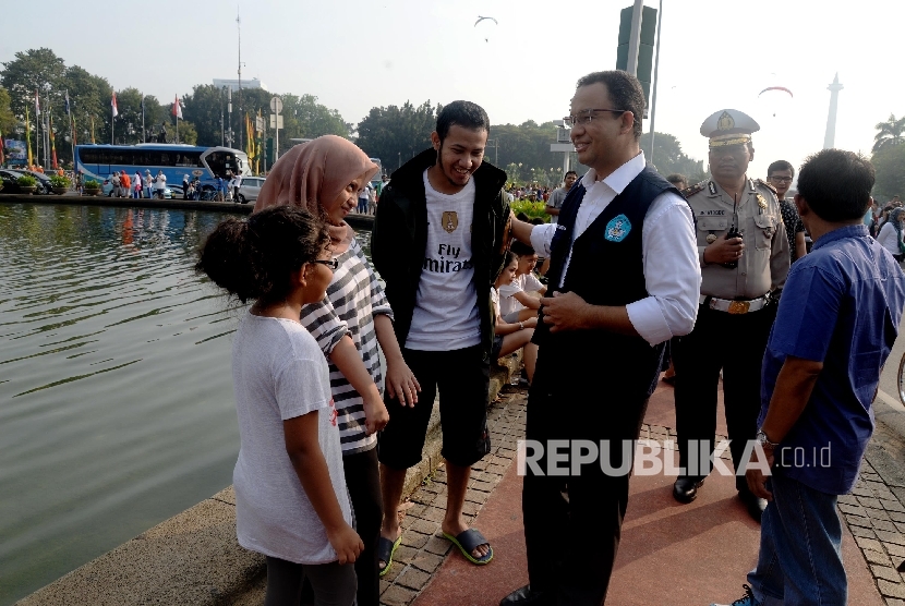 Menteri Pendidikan dan Kebudayaan Anies Baswedan berbincang dengan pengunjung car free day saat sosialisasi kampanye anter anak pada hari pertama sekolah di Patung Kuda, Jakarta, Ahad (17/7). (Republika/Yasin Habibi) 