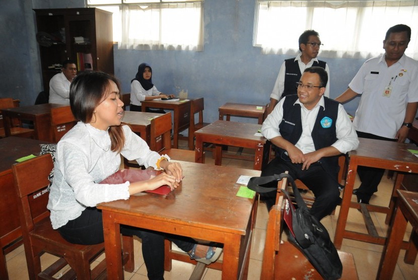 Menteri Pendidikan dan Kebudayaan Anies Baswedan (kedua kanan) berbincang dengan salah satu peserta Ujian Nasional (UN) kesetaraan Paket C saat meninjau pelaksanaannya di SMA Al-Muhajirin, Depok, Jawa Barat, Rabu (6/4). 
