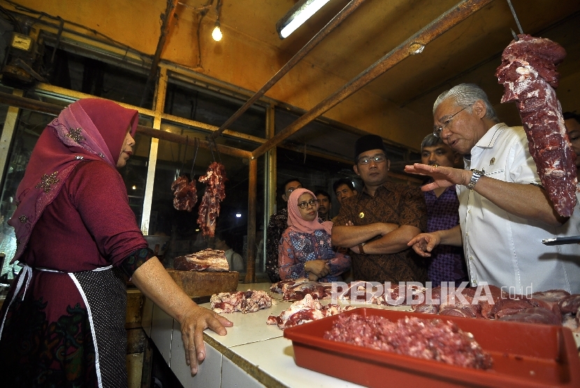 Menteri Perdagangan Enggartiasto Lukita didampingi Walikota Bandung Ridwan Kamil berbincang dengan pedagang daging sapi saat melakukan kunjungan ke Pasar Kosambi, Jalan Ahmad Yani, Kota Bandung, Jumat (5/5)