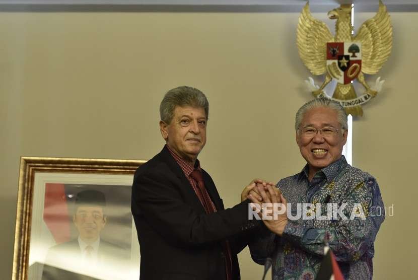 Menteri Perdagangan Enggartiasto Lukita (kanan) berjabat tangan dengan Duta Besar Palestina untuk Indonesia Zuhair Al Shun (kiri) usai penandatanganan Nota Kesepahaman terkait pengaturan bea masuk kurma dan minyak zaitun Palestina ke Indonesia di Jakarta, Senin (6/8). 