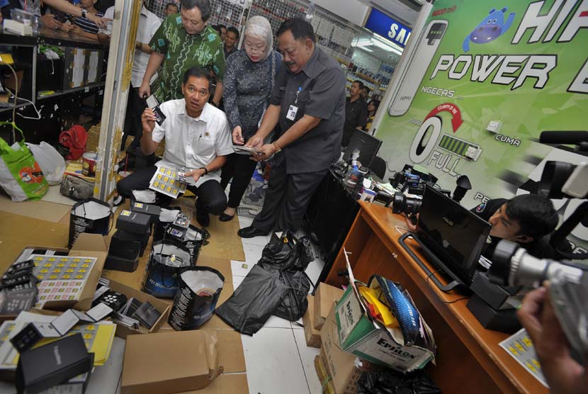  Menteri Perdagangan Gita Wirjawan (baju putih) memeriksa kartu garansi sebuah ponsel saat sidak peredaran ponsel ilegal di Pusat Perbelanjaan Roxy, Jakarta, Rabu (8/5).  (Antara/Yudhi Mahatma)