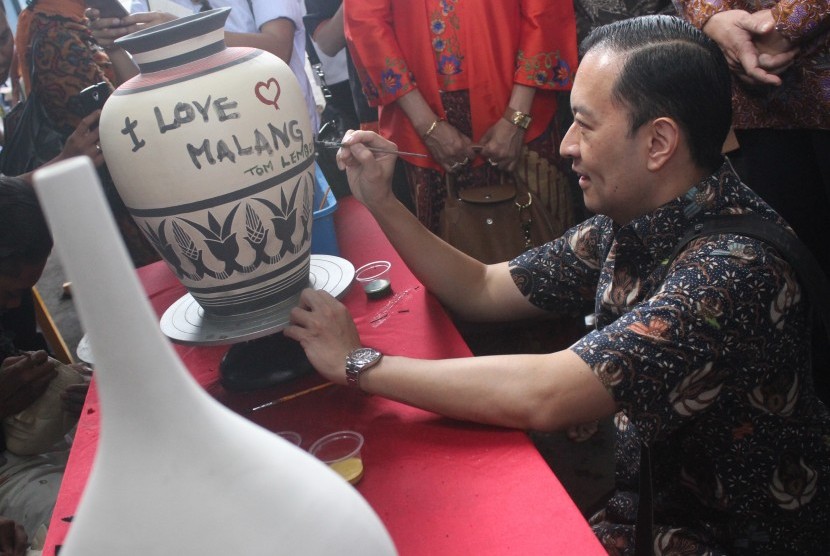 Menteri Perdagangan Thomas Trikasih Lembong melukis di atas keramik saat berkunjung di sentra kerajinan keramik Dinoyo, Malang, Jawa Timur, Jumat (1/4).