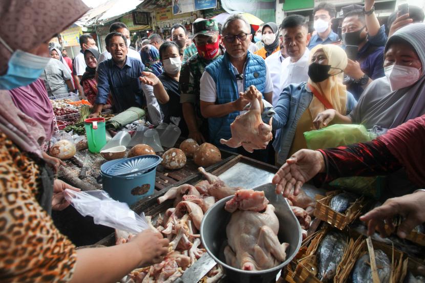 Menteri Perdagangan Zulkifli Hasan (tengah) berbincang dengan pedagang yang melayani ibu-ibu berbelanja di Pasar Dukuh Kupang, Surabaya, Jawa Timur, Ahad (14/8/2022). Kunjungan Mendag untuk memantau harga sejumlah bahan pokok di pasar tersebut.