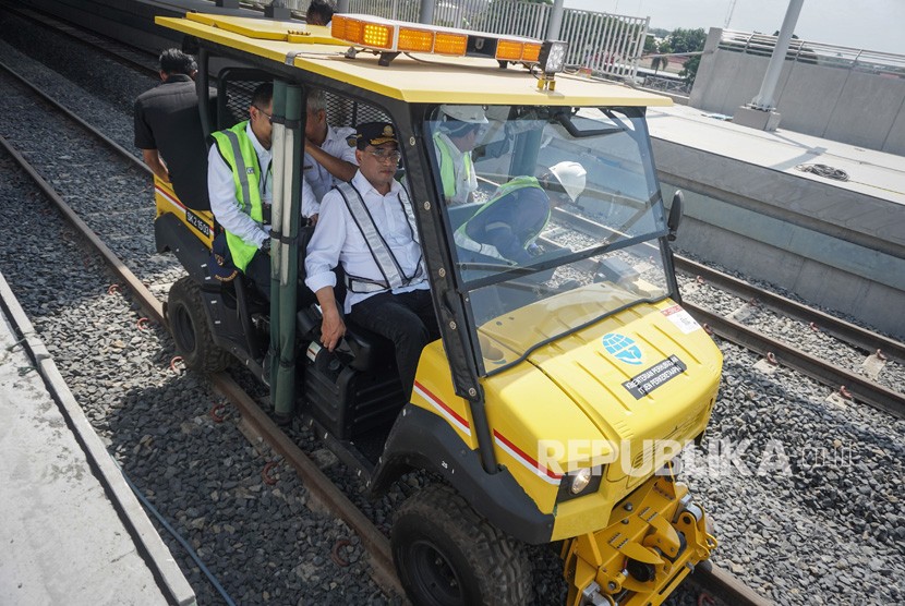 Menteri Perhubungan Budi Karya Sumadi (ketiga kanan) naik mobil lori saat meninjau proyek pembangunan kereta.