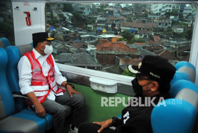 Menteri Perhubungan Budi Karya Sumadi (kiri) bersama Wali Kota Bogor Bima Arya (kanan) naik Kereta Pangrango saat meninjau persiapan pengoperasian kembali KA rute Bogor-Sukabumi di Kota Bogor, Jawa Barat, Ahad (3/4/2022). 