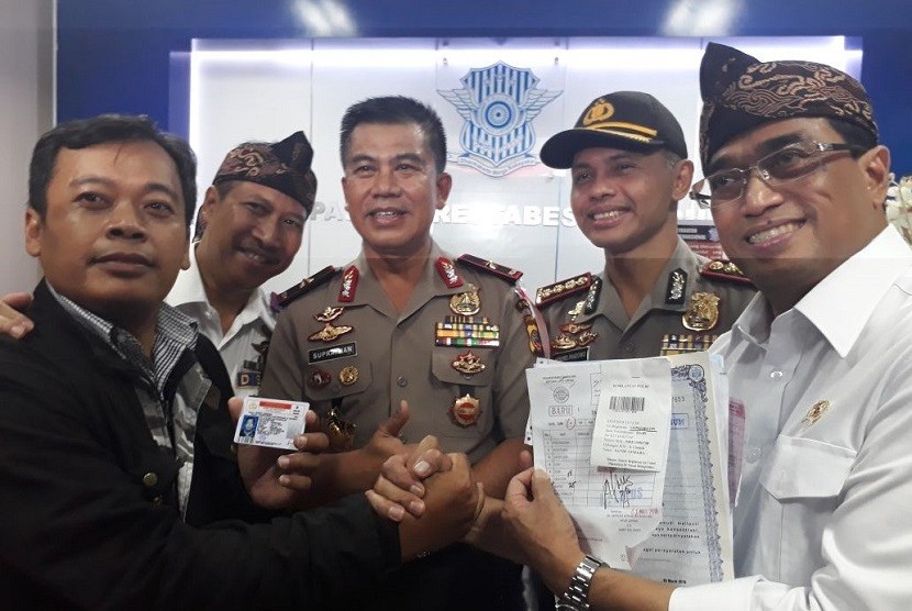 Menteri Perhubungan (Menhub) Budi Karya Sumadi bersama pengemudi taksi daring yang sudah melakukan pembuatan SIM A Umum bersubsidi di Kepolisian Resor Kota Besar Bandung, Sabtu (3/3). 