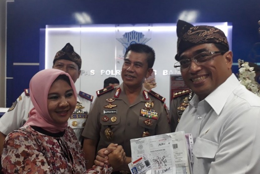 Menteri Perhubungan (Menhub) Budi Karya Sumadi bersama pengemudi taksi daring yang sudah melakukan pembuatan SIM A Umum bersubsidi di Kepolisian Resor Kota Besar Bandung, Sabtu (3/3). 
