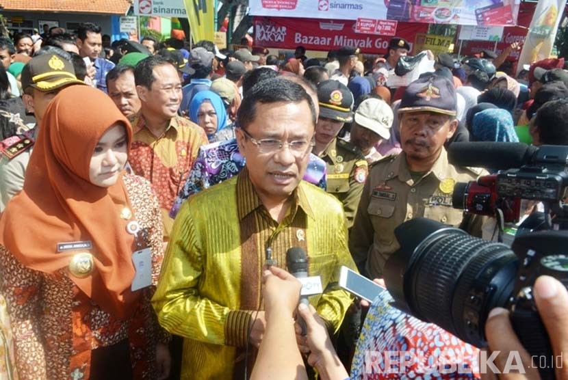  Menteri Perindustrian Saleh Husin bersama Bupati Kendal Mirna Annisa memberikan keterangan kepada awak media seusai meninjau dan melayani Bazar Minyak Goreng di Alun-alun Kendal, Jawa Tengah, 24 Juni 2016.