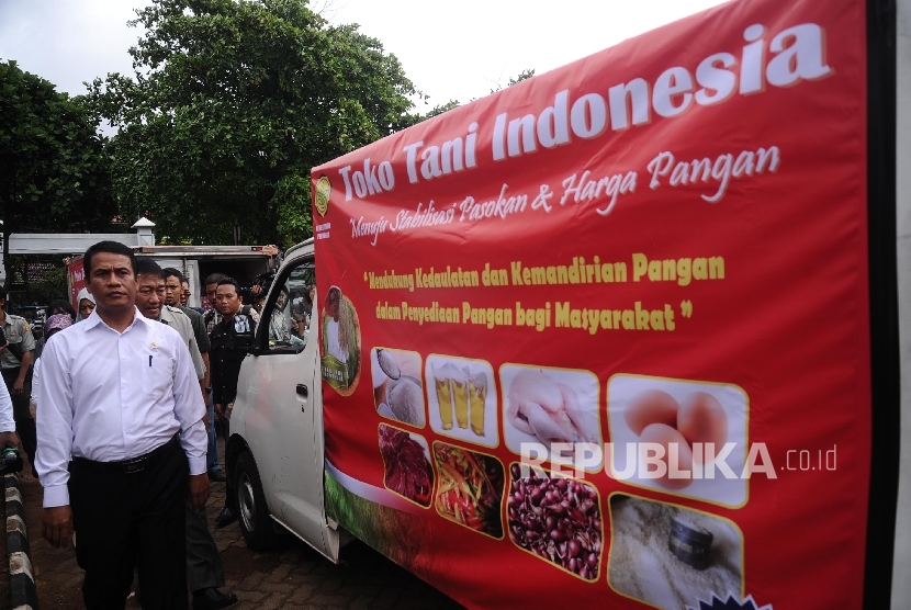 Menteri Pertanian Amran Sulaiman berjalan disamping kendaraan yang akan mendistribusikan bahan pokok untuk Toko Tani Indonesia (TTI) di Jakarta, Senin (6\2).