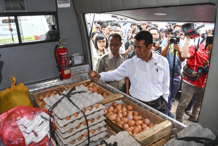 Menteri Pertanian Amran Sulaiman (kanan) didampingi Kepala Badan Ketahanan Pangan Agung Hendriadi (kedua kiri) memeriksa telur ayam yang akan didistribusikan untuk operasi pasar di Toko Tani Indonesia Centre, Jakarta Selatan, Kamis (19/7).