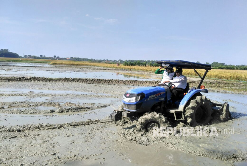 Menteri Pertanian Amran Sulaiman mencoba traktor milik petani di lokasi persawahan yang terletak di desa Samberan,  Kecamatan Kanor, Bojonegoro-Jawa Timur.