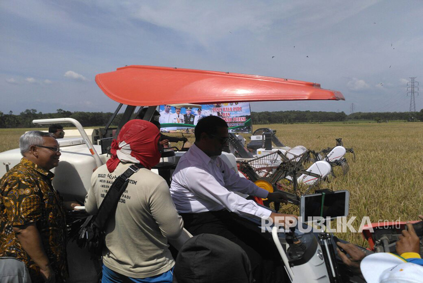 Menteri Pertanian Amran Sulaiman mencoba traktor milik petani di lokasi persawahan yang terletak di desa Karangbanyu,  Kecamatan Widodaren,  Ngawi-Jawa Timur