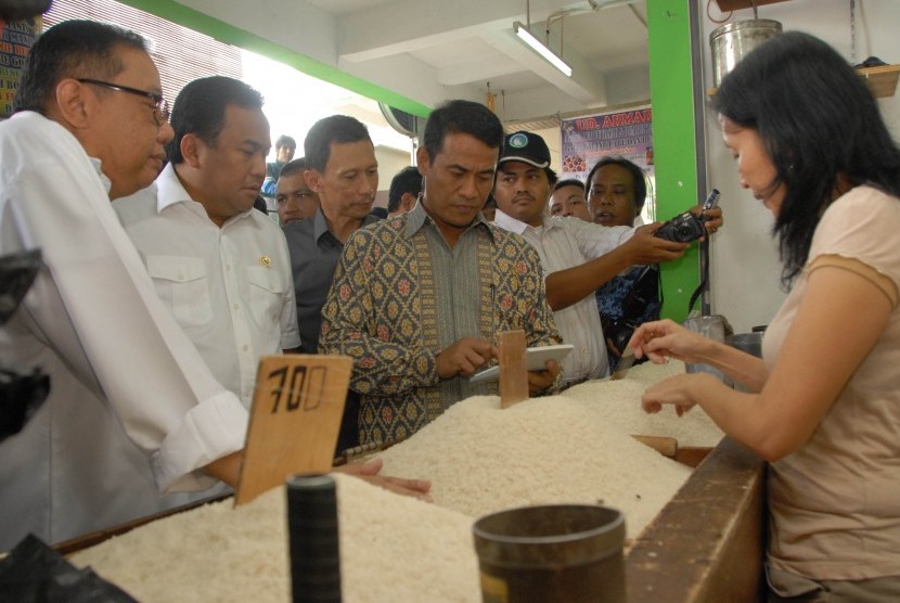 Menteri Pertanian, Andi Amran Sulaiman (tengah) bersama menteri Koperasi dan UKM AAGN Puspayoga (kiri) dan Menteri Perdagangan Rachmat Gobel (2 kiri) berbincang dengan pedagang beras saat inspeksi mendadak (sidak) di Pasar Cibinong, Kabupaten Bogor, Jabar,