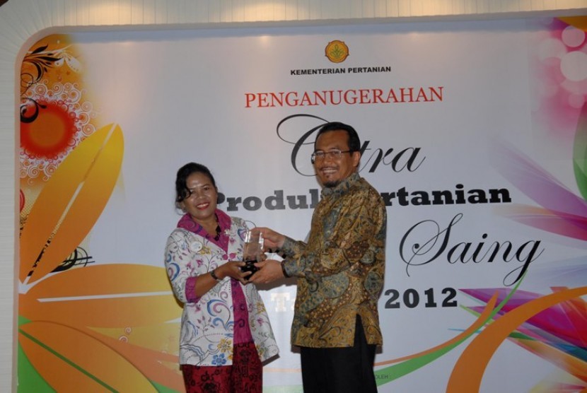 Menteri Pertanian, Suswono memberikan penghargaan kepada Sri Mulyati, inovator telur asin aneka rasa saat acara penganugerahan citra produk pertanian berdaya saing di Jakarta, Senin (17/12)