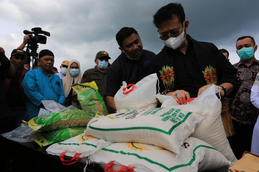 Menteri Pertanian Syahrul Yasin Limpo (kanan) melihat beras produk lokal saat kunjungan kerja pada gerakan panen padi di area persawahan Desa Blang Miro, Simpang Tiga, Aceh Besar, Aceh, Jumat (4/3/2022). Mentan memastikan stok pangan jelang Ramadhan aman. Ilustrasi.