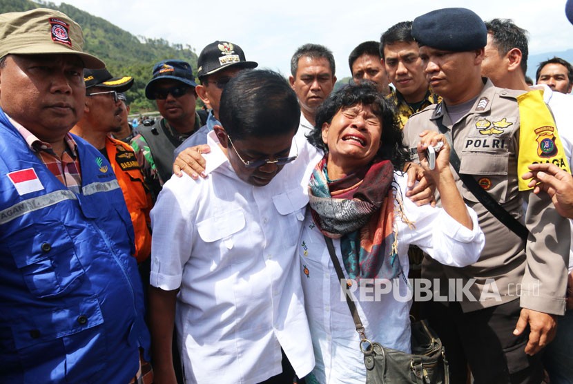 Menteri Sosial Idrus Marham (kedua kiri) memeluk Nuryati, keluarga penumpang KM Sinar Bangun saat meninjau lokasi tenggelamnya kapal, di Simalungun, Sumatera Utara, Ahad (24/6).