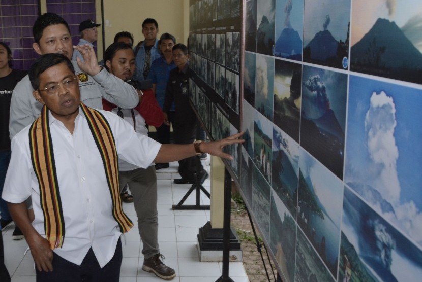 Menteri Sosial Idrus Marham (kiri) mengamati foto erupsi Gunung Agung saat melakukan kunjungan ke Pos Pemantauan Gunungapi Agung, Rendang, Karangasem, Bali, Sabtu (7/7). 