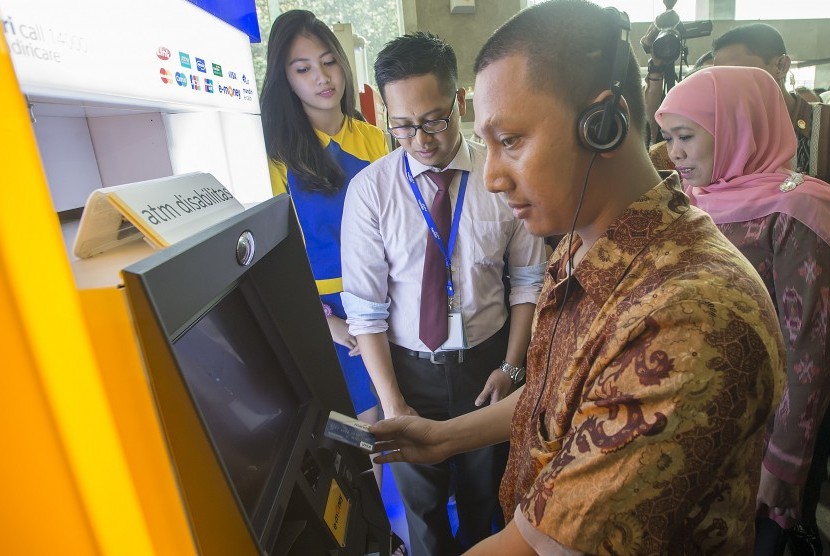 Nasabah disabilitas mencoba bertransaksi menggunakan mesin ATM di Gedung Kementerian Sosial, Jakarta, Selasa (1/12).