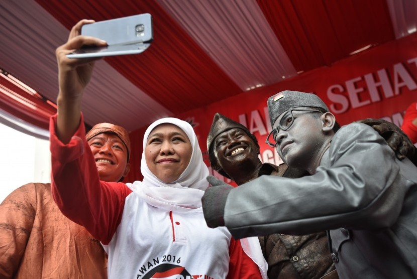 Menteri Sosial Khofifah Indar Parawansa (kedua kiri) berswafoto dengan sejumlah manusia patung karakter pahlawan ketika menghadiri jalan sehat dan doa lintas agama untuk pahlawan bangsa di kawasan Bundaran HI Jakarta, Minggu (6/11).