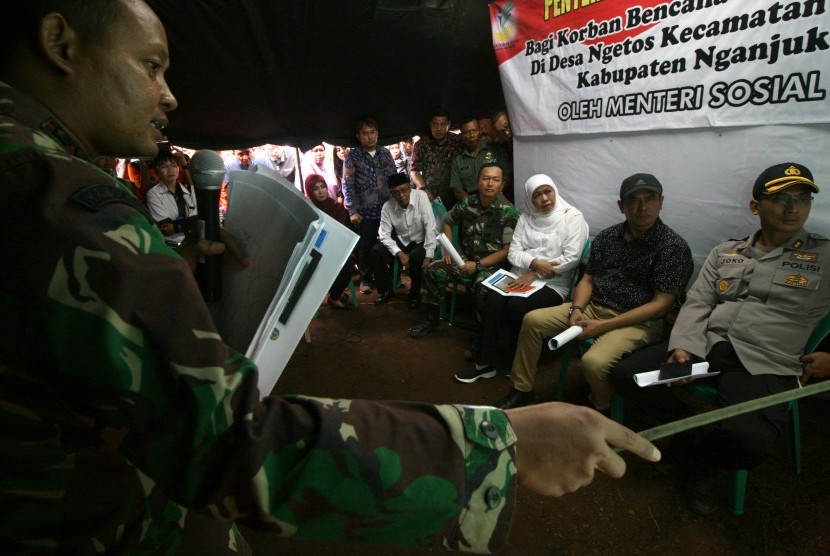 Menteri Sosial Khofifah Indar Parawansa (ketiga kanan) mendengarkan pemaparan yang disampaikan Dandim Nganjuk Letkol Arhanut Sri Rusyono (kiri) saat mengunjungi daerah longsor di Desa Janti, Nganjuk, Jawa Timur, Senin (10/4).