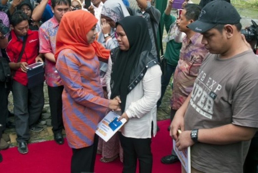 Menteri Sosial Khofifah Indar Parawansa (kiri) menyerahkan santuan kepada keluarga korban tewas akibat dampak kabut asap kebakaran di Kota Pekanbaru, Riau, Sabtu (31/10).