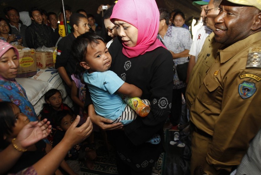 Menteri Sosial Khofifah Indar Parawansa mengendong balita di tenda pengungsian korban peristiwa penyerangan sekelompok massa beberapa waktu yang lalu di Distrik Karubaka, Tolikara, Papua, Selasa (21/7).