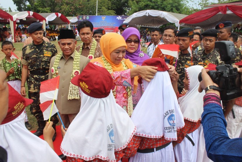 Menteri Sosial Khofifah Indar Parawansa (tengah) didampingi Regional CEO Bank Mandiri wilayah Kalimantan Anton Zulkarnain (keempat kiri), menyerahkan bantuan peralatan sekolah kepada siswa SD di Amuntai, Kalimantan Selatan, Kamis (27/7).  Selain bantuan kepada siswa, Bank Mandiri menyalurkan bantuan sosial Program Keluarga Harapan (PKH) sebesar Rp 9,019 miliar kepada 4.772 keluarga penerima manfaat di Kabupaten Hulu Sungai Utara, Kalimantan Selatan.