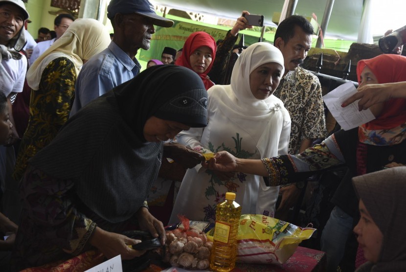 Menteri Sosial Khofifah Indar Parawansa (tengah) menyaksikan proses penukaran kupon sembako murah saat digelar pasar murah Mensos di Surabaya, Jawa Timur, Minggu (26/6). 