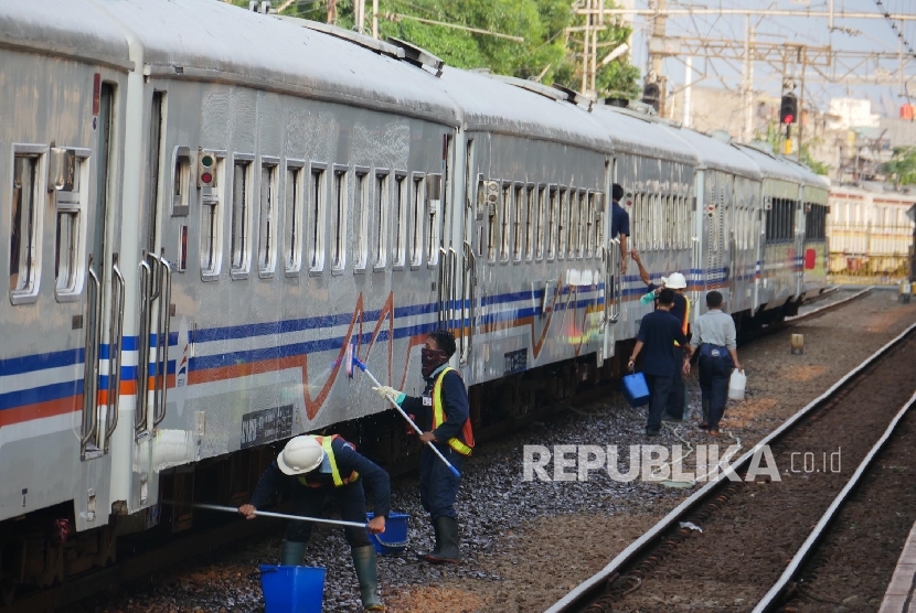 Menyuci kereta api di stasiun Senen Jakarta, Kamis (29/6). 