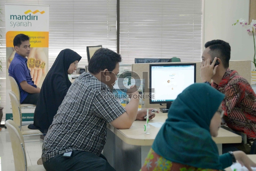 Merger Bank Umum Syariah: Petugas melayani nasabah di Bank Syariah Mandiri, Jakarta, Senin (23/2).