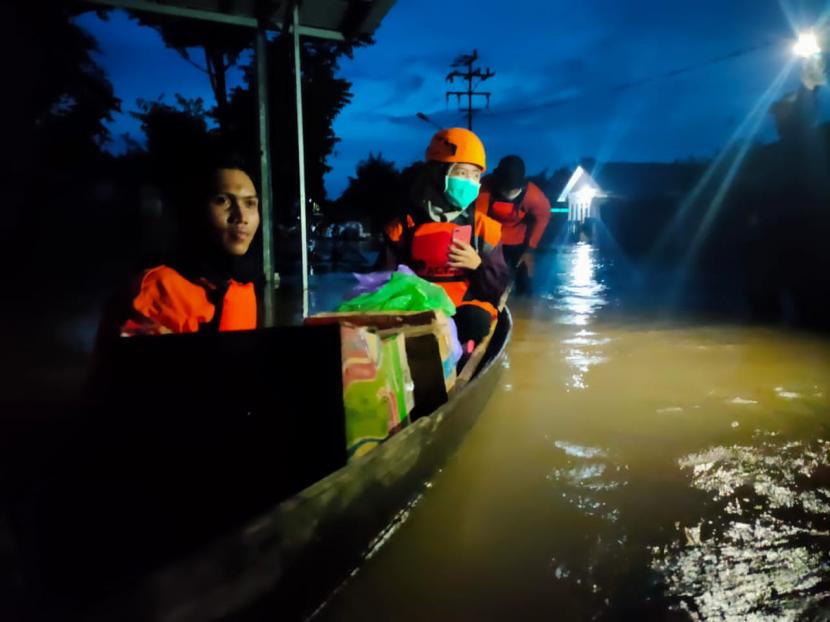 Warga naik sampan di kawasan banjir di Desa Kelampayan, Kecamatan Astambul, Kabupaten Banjar, Kalimantan Selatan.