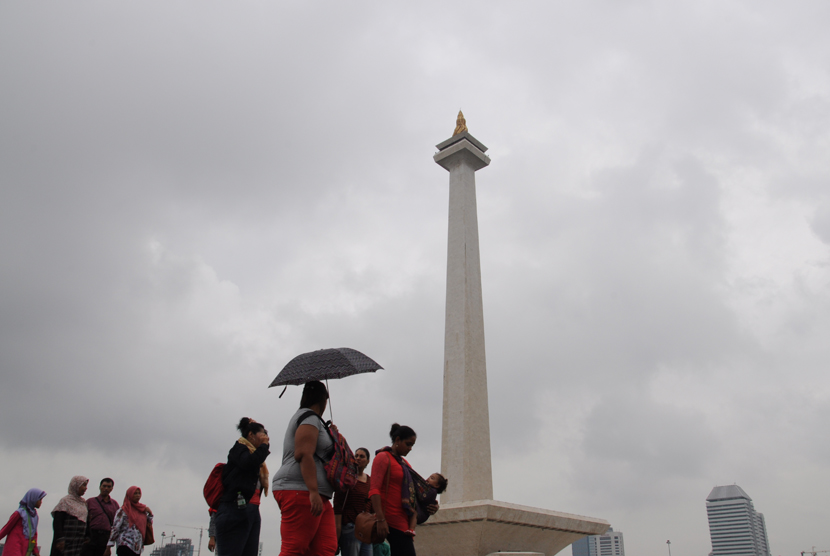   Meski hujan, banyak warga yang mengisi waktu libur dengan berwisata ke kawasan Monumen Nasional (Monas), Jakarta, Kamis (19/2).  (foto : MgROL_34)