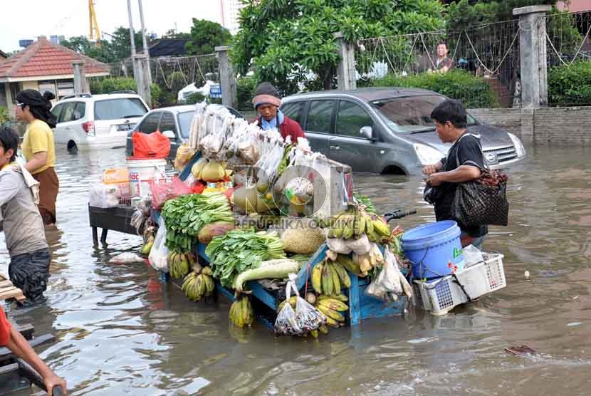  Meski masih tergenang air banjir,pedagang sayur keliling tetap berjualan melayani warga Apartemen Laguna Pluit di kawasan mewah Pluit, Penjaringan, Jakarta Utara, Ahad (20/1). (Republika/Rakhmawaty La'lang)