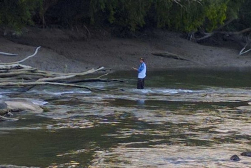 Meski telah ada peringatan soal buaya, seorang nelayan tetap menyebrang sungai.