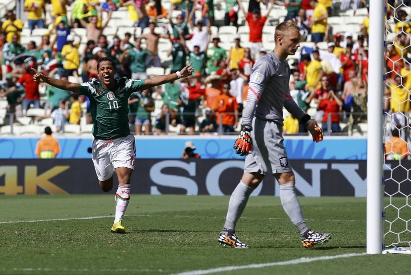 Mexico's Giovani Dos Santos (L) celebrates after scoring a goal past goalkeeper Jasper Cillessen of the Netherlands during their 2014 World Cup round of 16 game at the Castelao arena in Fortaleza June 29, 2014. No foul was called