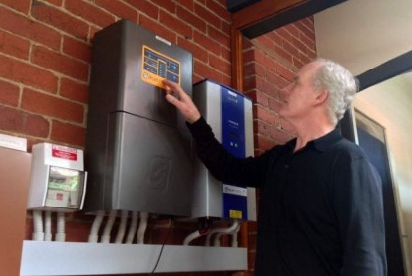 Michael McGarvie sedang menginstal sistem baterai panel surya di rumahnya di Melbourne.