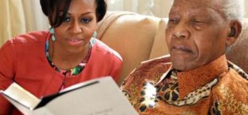 Michelle Obama bersama mantan presiden Afrika Selatan, Nelson Mandela, tengah membaca buku berjudul Nelson Mandela by Himself di kediaman Mandela, Johannesburg