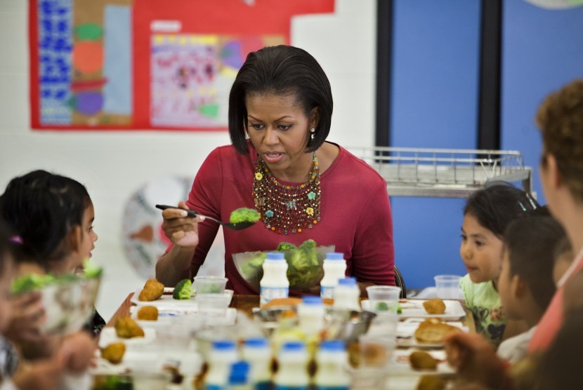 Michelle Obama mendampingi anak-anak makan di sekolahnya saat menggagas program makan sehat.