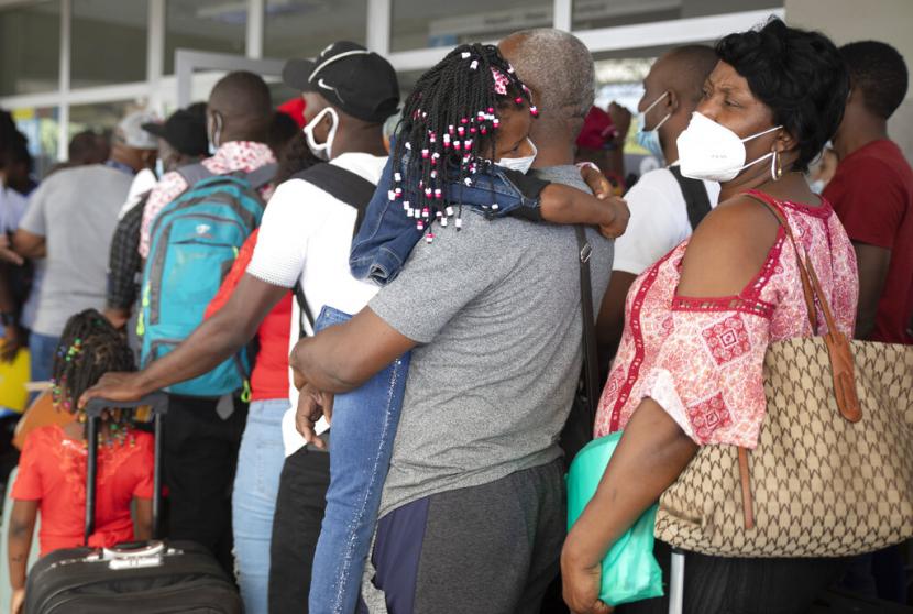 Migran Haiti menunggu dalam antrean untuk check-in untuk penerbangan ke Chili, di Bandara Internasional Toussaint Louverture, di Port-au-Prince, Haiti, Minggu, 30 Januari 2022.