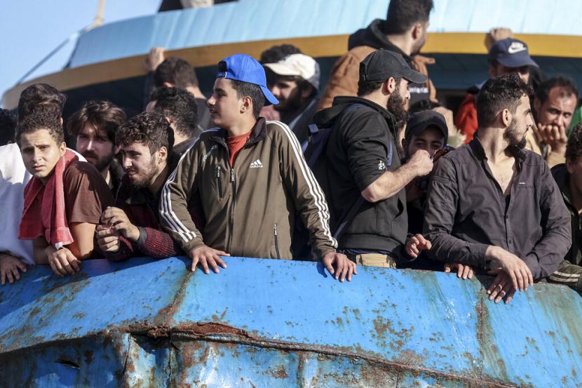 Migran melihat keluar dari kapal nelayan yang berlabuh di pelabuhan Palaiochora di tenggara Kreta, Yunani, setelah kedatangannya, pada Selasa, 22 November 2022. 