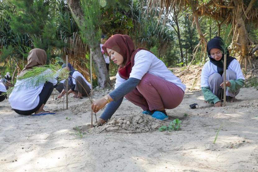Milenial mengikuti kegiatan tanam pohon cemara udang bersama Kelompok Sadar Wisata (Pokdarwis) di Pantai Panduri Tasikharjo, Kabupaten Tuban, Jawa Timur. 