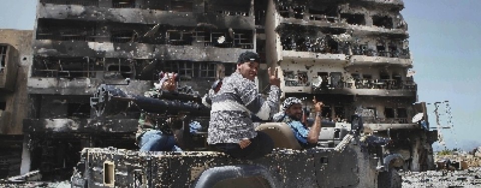 Milisi oposisi tengah berkendara di salah satu sudut kota Misrata.